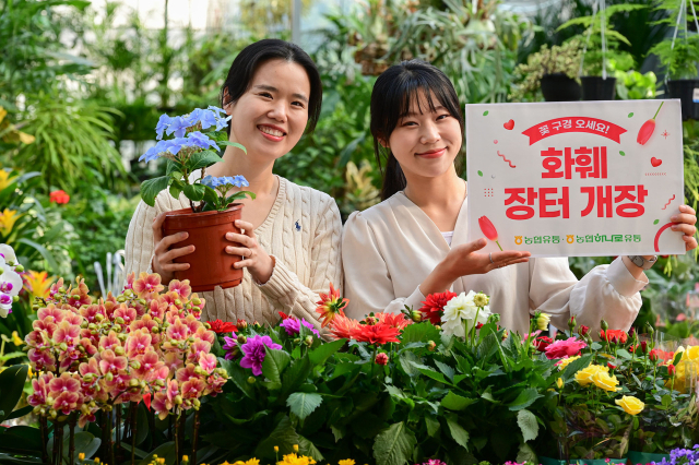 3일 경기도 수원시 권선구 농협 하나로마트 수원점에서 모델들이 봄꽃 행사를 알리고 있다. 연합뉴스