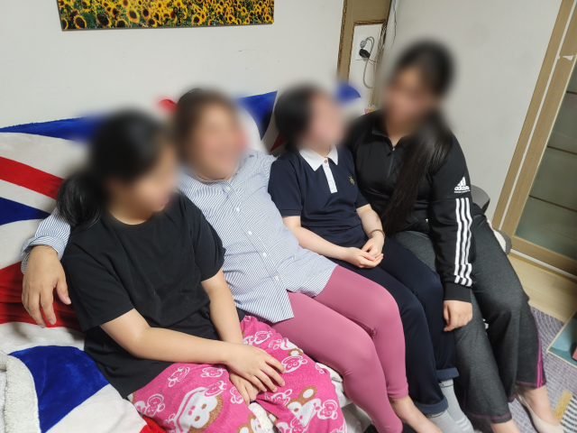 지난 5일 김기진(가명·45) 씨와 세 딸이 소파 위에서 이야기를 나누고 있다. 박성현 기자
