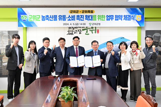 대구 군위군과 군위축협이 농산물 유통, 소비 축진을 위한 업무협약을 체결하고, 기념 사진을 촬영하고 있다. 군위군 제공