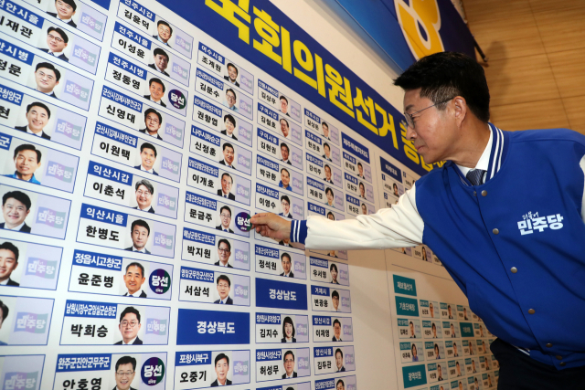 더불어민주당 조정식 사무총장이 10일 국회 의원회관 제22대 국회의원선거 상황실에서 당선 의원의 이름 옆에 스티커를 붙이고 있다. 연합뉴스