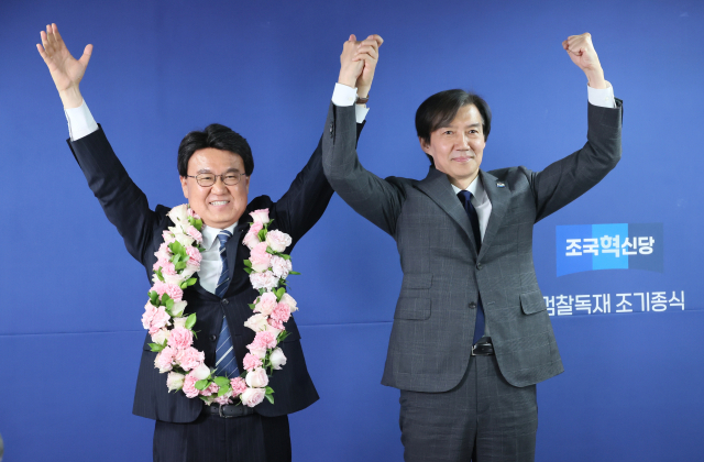 조국혁신당 조국 대표가 11일 서울 여의도 당사에서 열린 조국혁신당 파란불꽃선대위 해단식에서 황운하 당선인에게 꽃목걸이를 걸어준 뒤 포즈를 취하고 있다. 연합뉴스
