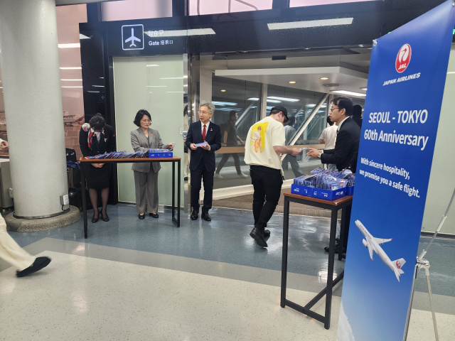 일본항공이 15일 탑승객들에게 60주년 기념일 임을 알리며 탑승 게이트에서는 안전운항 의미가 담긴 한정판 키 홀더를 탑승객 전원에게 나누어 주었다. 일본항공 제공