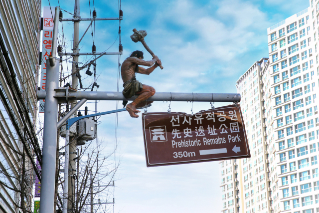 달서구 월배로와 상화로 일대에 있는 원시인 모형. 원시인 모형이 교통표지판 위에 올라가 있다.