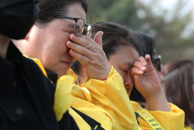 16일 오후 경기도 안산시 화랑유원지에서 열린 '세월호 참사 10주기 기억식'에서 참석자들이 눈물을 닦고 있다. 연합뉴스
