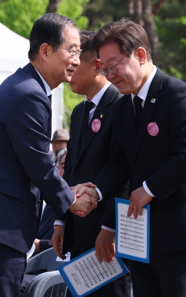 한덕수 국무총리가 19일 오전 서울 강북구 국립 4·19민주묘지에서 열린 제64주년 4·19 혁명 기념식을 마친 뒤 더불어민주당 이재명 대표와 인사하고 있다. 연합뉴스