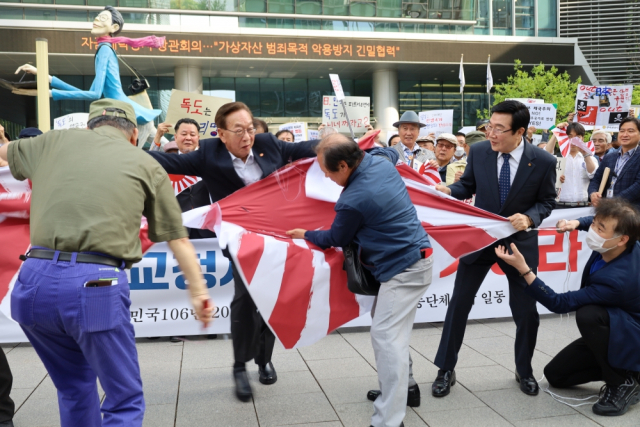 지난 19일 오후 서울 종로구 수송동 평화의 소녀상 인근에서 광복회와 3·1운동기념사업회 등 33개 독립운동 단체 관계자들이 일본 외교청서의 '독도는 일본 땅'이라는 주장을 규탄하며 욱일기를 찢는 퍼포먼스를 하고 있다. 연합뉴스