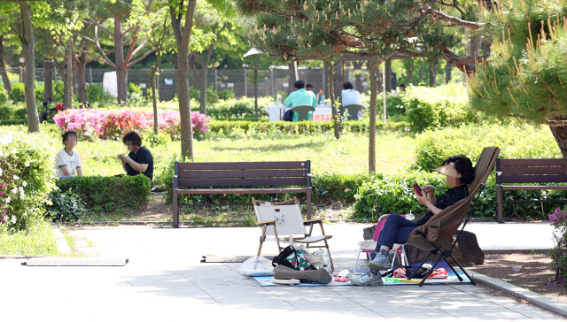 낮 최고기온이 21∼30도로 초여름의 날씨를 보이는 27일 서울 관악구 낙성대공원에서 시민들이 그늘에 앉아 휴식을 취하고 있다. 연합뉴스