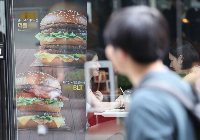 28일 오후 서울 중구 명동 거리 한 음식점에 햄버거 메뉴 사진 안내판이 붙어 있다. 연합뉴스