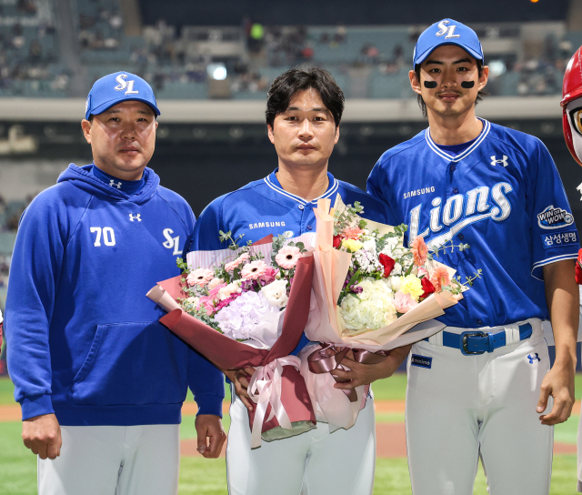 삼성 라이온즈의 오승환(가운데)이 지난 26일 서울 고척스카이돔에서 열린 키움 히어로즈전에 마무리로 등판해 아시아 단일리그 최다 세이브 신기록을 세운 뒤 박진만 삼성 감독, 구자욱 삼성 주장의 축하를 받으며 기념 사진을 찍고 있다. 삼성 제공