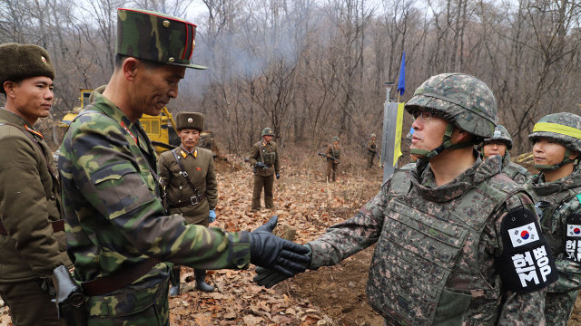 지난 2018년 11월 강원도 철원 비무장지대(DMZ) 내 화살머리고지에서 도로연결 작업에 참여한 남북인원들이 군사분계선(MDL) 인근에서 인사하는 모습. 국방부 제공