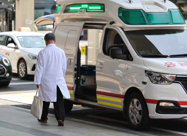 서울 시내 한 대형병원에서 한 의료관계자가 구급차 앞을 지나고 있다. 연합뉴스