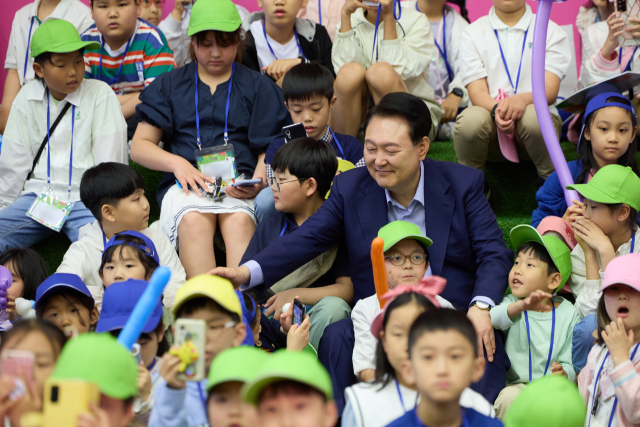 윤석열 대통령이 5일 청와대 연무관에서 열린 어린이날 초청 행사에 참석해 '버블 매직쇼' 공연을 관람하는 어린이들과 대화하고 있다. 연합뉴스