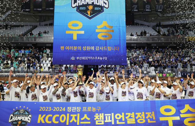 챔피언 자리에 오른 KCC 선수들이 트로피를 들고 기뻐하고 있다. 연합뉴스