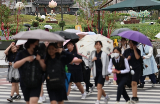 서울 전역에 비가 내린 7일 오후 서울 종로구 송현동공원 인근에서 시민들이 우산을 쓰고 이동하고 있다. 연합뉴스