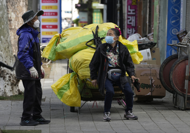 대구 동구의 한 재활용센터 인근에서 폐지를 옮기던 어르신이 손수레에 앉아 휴식을 취하고 있다. 매일신문 DB