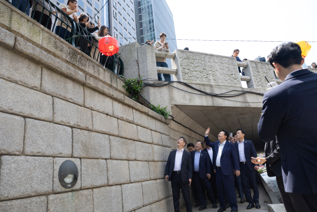 윤석열 대통령이 10일 서울 중구 청계천을 찾아 인근 직장인, 시민들과 인사하고 있다. 연합뉴스