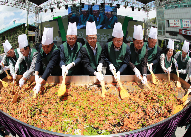 제19회 영양산나물축제장에서 오도창 영양군수와 김석현 영양군의회 의장, 박형수 국회의원, 김학홍 경북도 행정부지사 등 내빈들이 일월산 높이를 상징하는 1천219인분의 산나물 비빔밥 만들기 퍼포먼스를 진행하고 있다. 영양군 제공