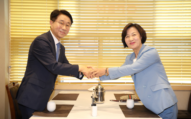 더불어민주당 소속 추미애(오른쪽)·조정식 국회의장 후보가 12일 오후 서울 여의도의 한 식당에서 국회의장 후보 단일화를 논의하기 위해 회동하며 손잡고 있다. 연합뉴스