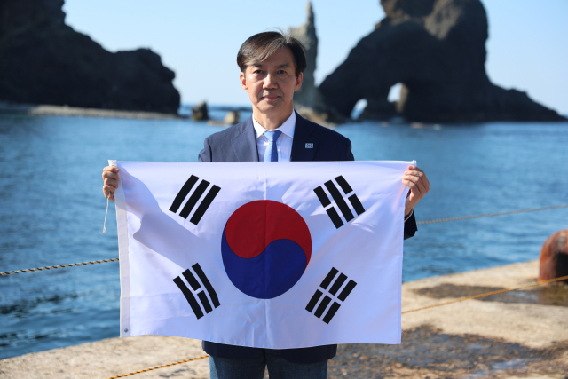 조국혁신당 조국 대표가 13일 경북 울릉군 독도를 찾아 태극기를 들고 기념 촬영하고 있다. 연합뉴스