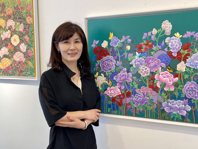 김유경 작가가 자신의 작품 앞에서 포즈를 취하고 있다. 이연정 기자