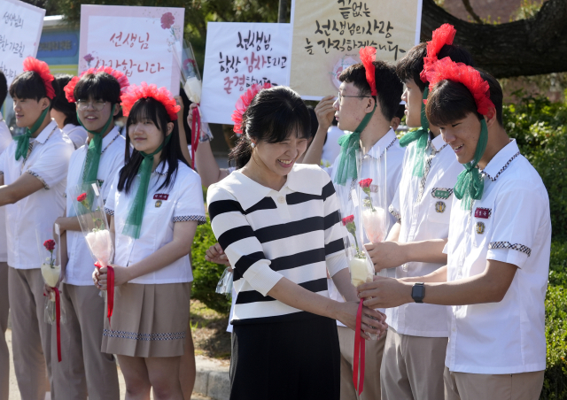 지난 14일 대구농업마이스터고등학교에서 인간 카네이션으로 분장한 학생들이 출근하는 선생님에게 감사의 마음을 담은 카네이션을 전달하고 있다. 매일신문 DB