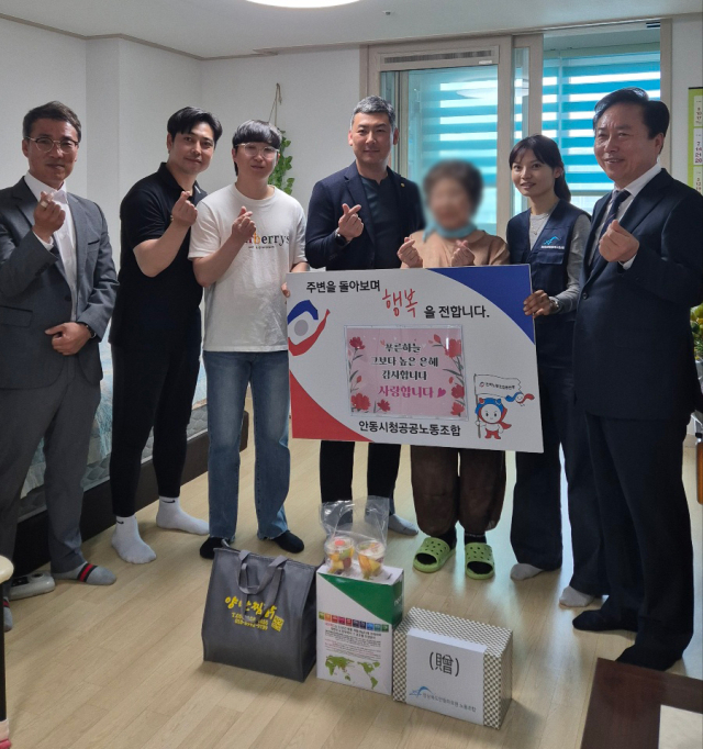 안동시청공공노동조합과 PP스포츠센터, 안동의료원노동조합이 지역 내 이웃에게 생필품 등을 전달하고 기념 촬영을 하고 있다. 권기창 안동시장(오른쪽)은 이날 봉사에 깜짝 방문해 시민과 단체 관계자들을 격려했다. 안동시공공노조 제공