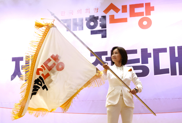 19일 국회 의원회관에서 열린 개혁신당 전당대회에서 신임 당 대표로 선출된 허은아 후보가 이준석 대표로부터 당기를 건네받아 흔들고 있다. 연합뉴스