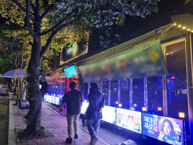 지난 14일 0시쯤 방문한 대구 동구 동촌유원지 일대 한 음식점. 흥이 오른 손님들이 단체로 음악에 맞춰 디제잉석 앞에서 춤을 추고 노래를 부르고 있다. 음식점 외부에 걸린 현수막 위로 