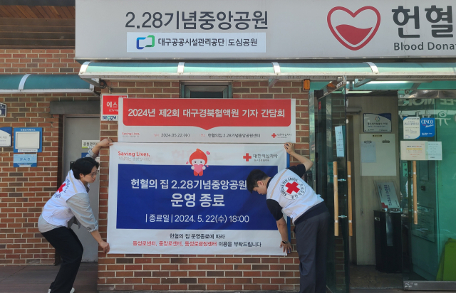 22일 대한적십자사 직원들이 헌혈의집 2·28기념중앙공원센 운영 종료를 알리는 현수막을 부착하고 있다. 남정운 수습기자