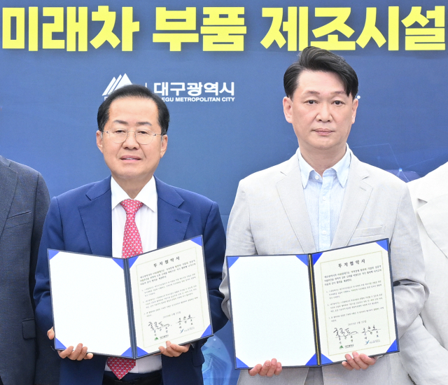 22일 대구시청 산격청사에서 홍준표 대구시장(왼쪽)과 조현호 (주)유림테크 대표가 투자 협약을 체결하고 기념촬영을 했다. 대구시 제공