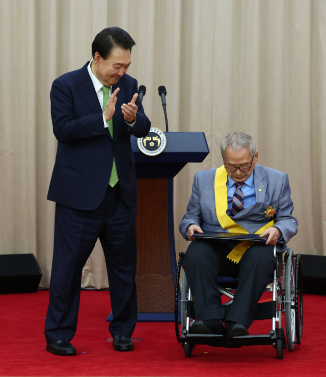 윤석열 대통령이 22일 서울 서초구 대한민국학술원에서 열린 개원 70주년 기념식에서 자연기초 분야 이상만 회원에게 국민훈장 무궁화장을 수여한 뒤 박수를 치고 있다. 연합뉴스