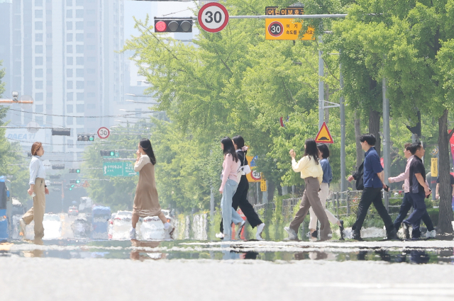 초여름 날씨를 보인 지난 22일 오후 서울 영등포구 여의도공원 인근 도로에서 지열에 의한 아지랑이가 피어오르고 있다. 연합뉴스