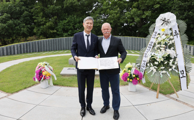 야노시 차크(Janos Csak) 헝가리 문화혁신부 장관이 25일 오후 경기 파주시 탄현면 동화경모공원 노태우 전 대통령 묘소를 찾아 참배한 뒤 노태우 전 대통령 아들 노재헌 동아시아문화센터 원장과 기념사진을 촬영하고 있다. 연합뉴스