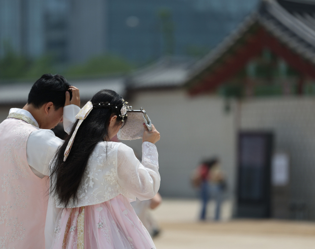 지난 5월 서울 종로구 경복궁을 찾은 외국인이 가방으로 햇빛을 가리고 있다. 사진은 기사 내용과 관계 없음. 연합뉴스