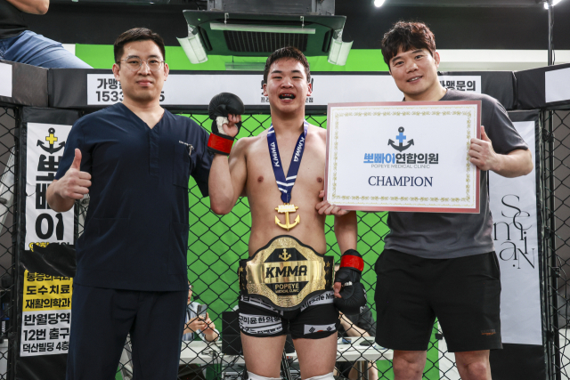 KMMA 제2대 페더급 챔피언 김채현(중간)과 김대환 KMMA대표, 메인 스폰서 뽀빠이연합의원 김성배 대표원장이 기념사진을 찍고 있다. KMMA 제공