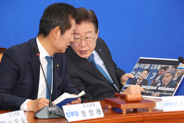 더불어민주당 이재명 대표가 29일 오전 서울 여의도 국회에서 열린 최고위원회의에서 윤석열 대통령과 이종섭 전 국방부 장관의 통화 사실을 보도한 자료를 보며 정청래 최고위원과 대화하고 있다. 연합뉴스