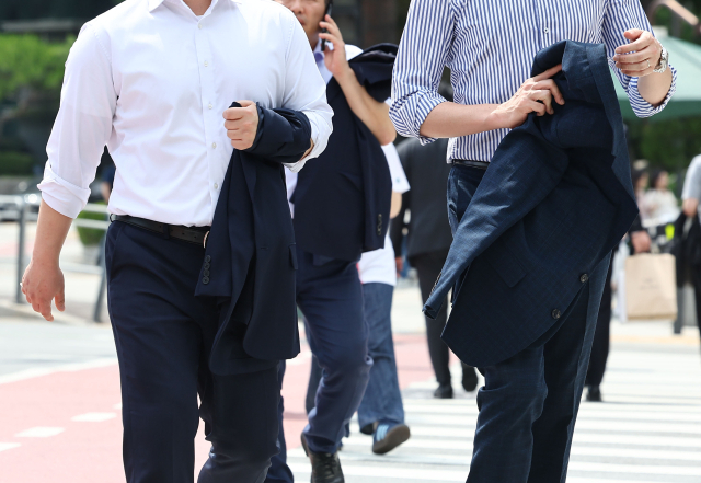 지난 29일 오후 더운 날씨를 보이는 서울 남대문시장 인근에서 직장인들이 외투를 벗은 채 걸어가고 있다. 연합뉴스