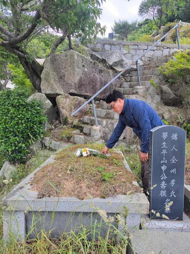 신경용 금화복지재단 이사장이 지난 1일 아버지(신수근) 산소를 찾아 꽃을 올려놓고 있다. 신경용 씨 제공