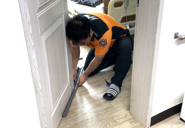 영천소방서 소방관이 노약자 시설 출입문에 방연 문틈 가스켓을 설치하고 있다. 영천소방서 제공