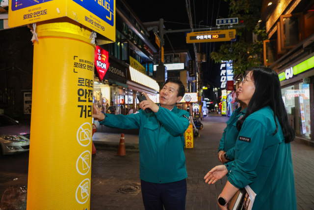 지난달 31일 류규하 중구청장(왼쪽)이 중구 로데오거리내 로데오안전거리 표지판을 점검하고 있다. 중구청 제공