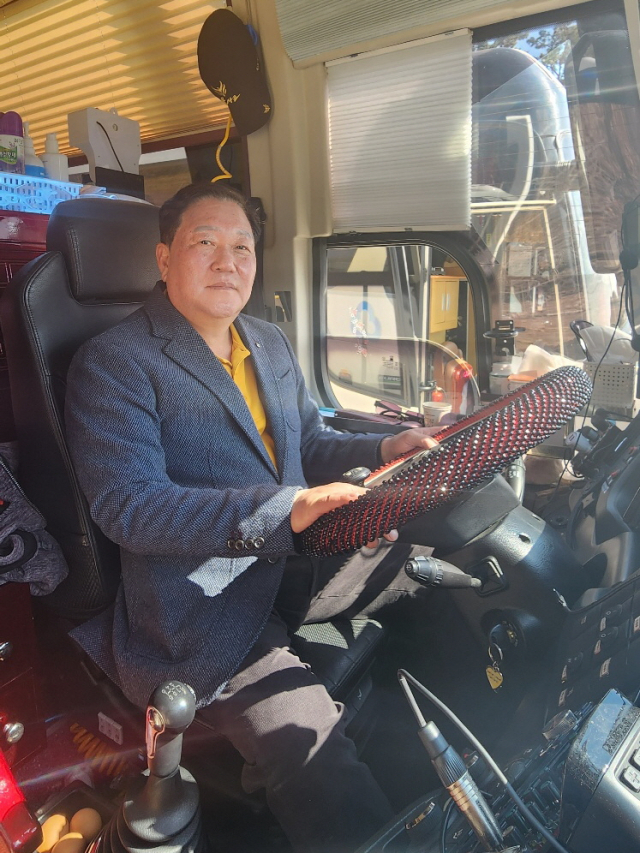 이정욱 구미 공단새마을금고 이사장이 버스운행 봉사를 하기 전 운전대를 잡고 포즈를 잡고 있다. 공단새마을금고 제공