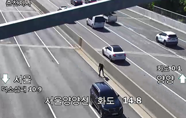4일 오전 경기 남양주시 서울양양고속도로 화도 IC 인근 도로에서 지폐가 도로에 떨어져 운전자들이 차를 세우고 돈을 줍고 있다. 연합뉴스