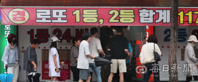 지난 6월 8일 대구 서구의 한 복권 판매점 앞에 로또를 사려는 손님들이 남녀노소 가리지 않고 길게 늘어서 있다. 매일신문 DB