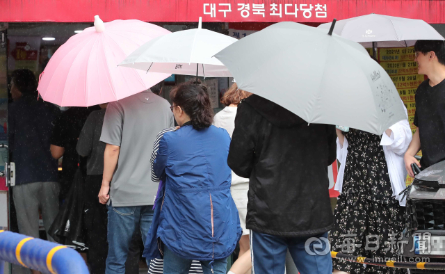 8일 오후 대구 달서구의 한 복권 판매점 앞에 로또를 사려는 손님들이 남녀노소 가리지 않고 길게 늘어서 있다. 이날 복권 행렬 속에 서 있던 김 모(58)씨는