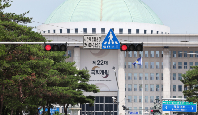 여야가 상임위원회를 배분하는 원구성 문제를 두고 강대강 대치를 이어가고 있는 9일 서울 여의도 국회의사당 앞 교통신호등 너머로 22대 국회개원 축하 현수막이 보인다. 연합뉴스