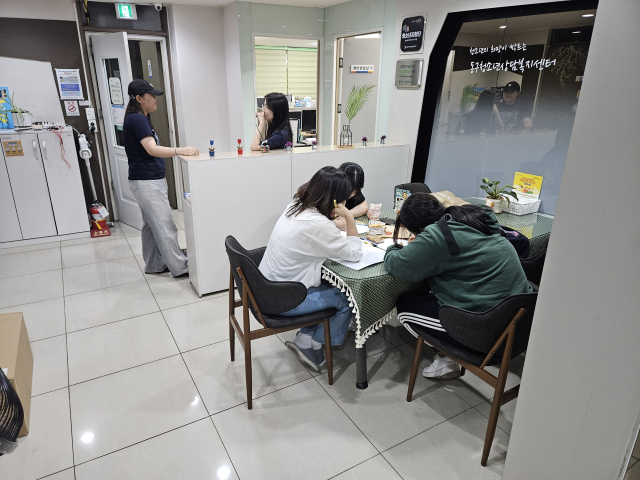 대구 동구 학교밖청소년지원센터 로비에 놓인 테이블에서 청소년들이 옹기종기 모여 과제를 하고 있다. 별도 학부모 대기 공간, 멘토링 공간, 자습 공간이 없어 시설 확충이 시급한 상황이다. 대구 동구 학교밖청소년지원센터 제공