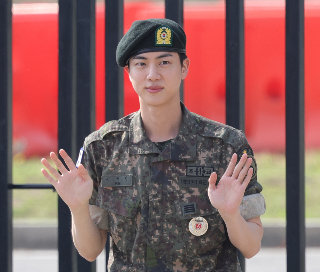 그룹 방탄소년단(BTS)의 진이 12일 오전 경기도 연천군 육군 5사단 신병교육대대에서 전역하며 손을 흔들고 있다. 연합뉴스