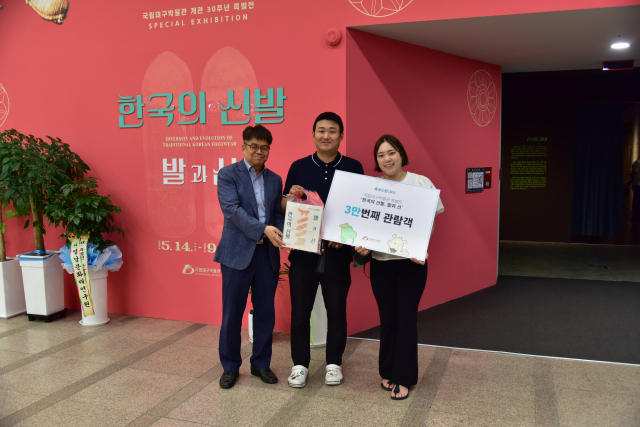 김규동(왼쪽) 국립대구박물관 관장이 특별전 3만번째 입장 관람객인 염건 씨가 기념사진을 찍고 있다. 국립대구박물관 제공