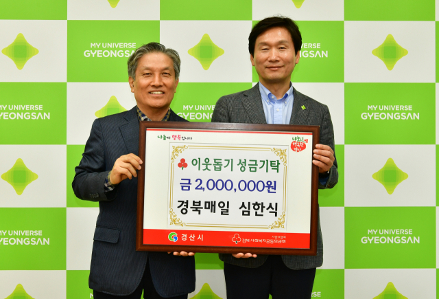 경북매일신문 심한식(왼쪽)기자가 13일 경산시에 이웃돕기 성금 200만원 기탁을 기탁했다.