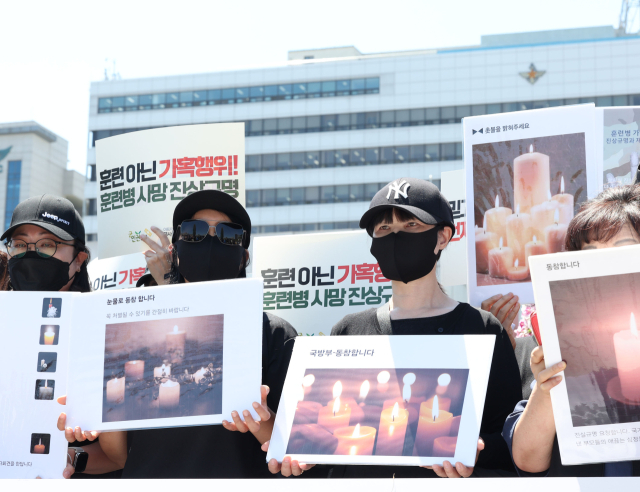 4일 서울 용산구 국방부 앞에서 열린 육군 12사단 훈련병 가혹행위 사망사건 규탄 및 진상규명 촉구 기자회견에서 현·전역 병사 부모들과 군인권센터 관계자들이 손팻말을 들고 있다. 연합뉴스